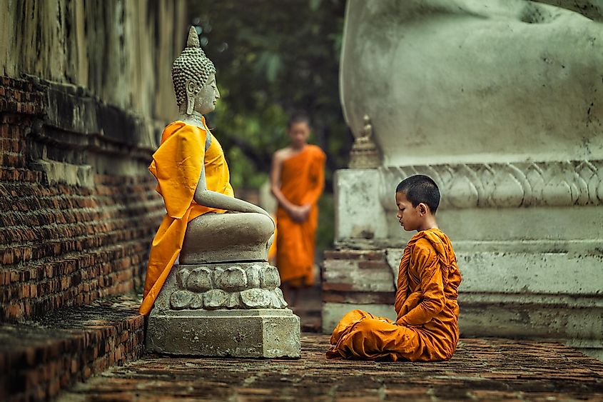 Индонезия мальчик-буддист перед статуей