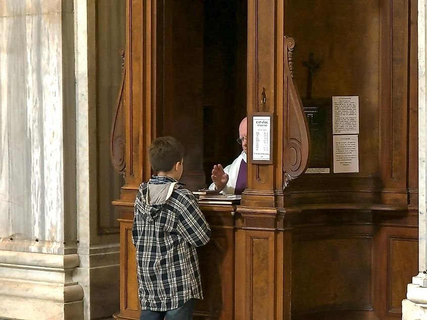 мальчик совершает католическую исповедь в базилике санта-мария-маджоре, рим