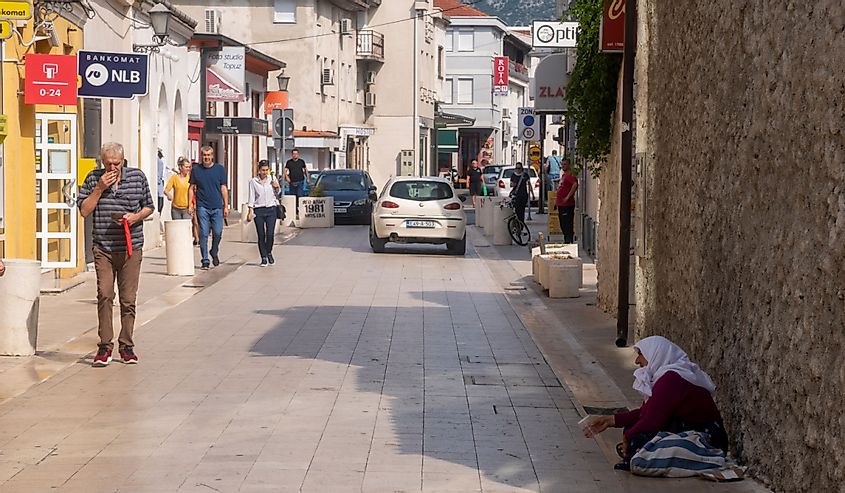 женщина попрошайничает на улице в центре Мостара, Босния и Герцеговина