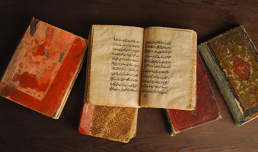 Стопка открытых древних книг на арабском языке.